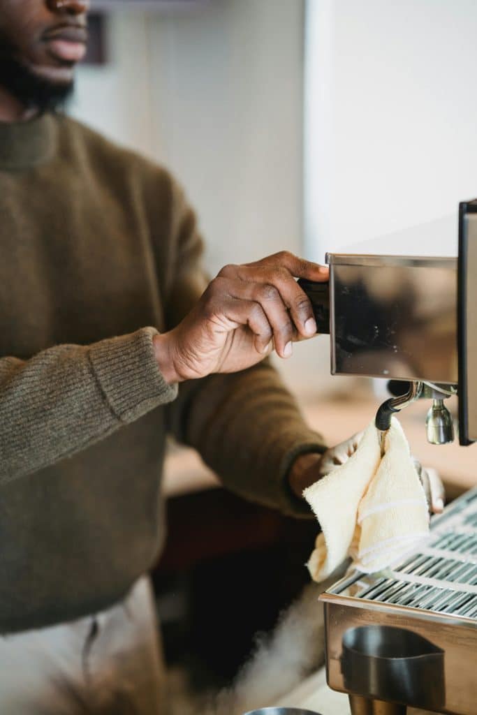 Une personne est en train de nettoyer une machine à café