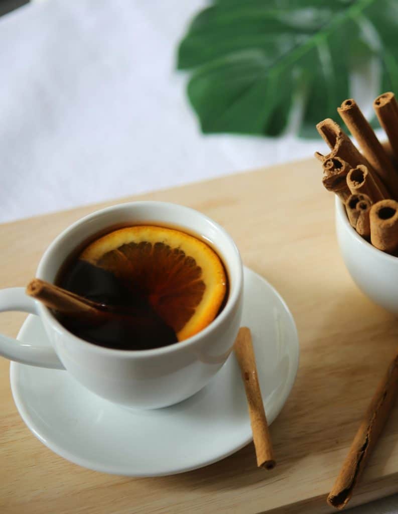 Une tasse de café et un pot de cannelle